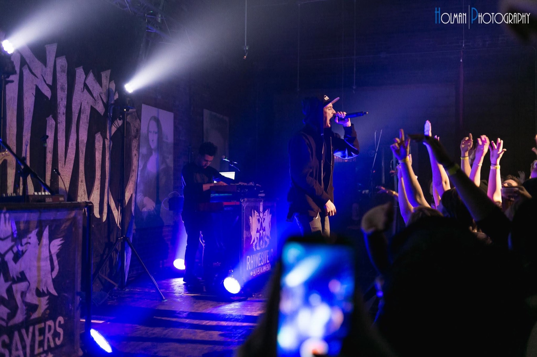 Grieves on stage in front of a Rhymesayers banner